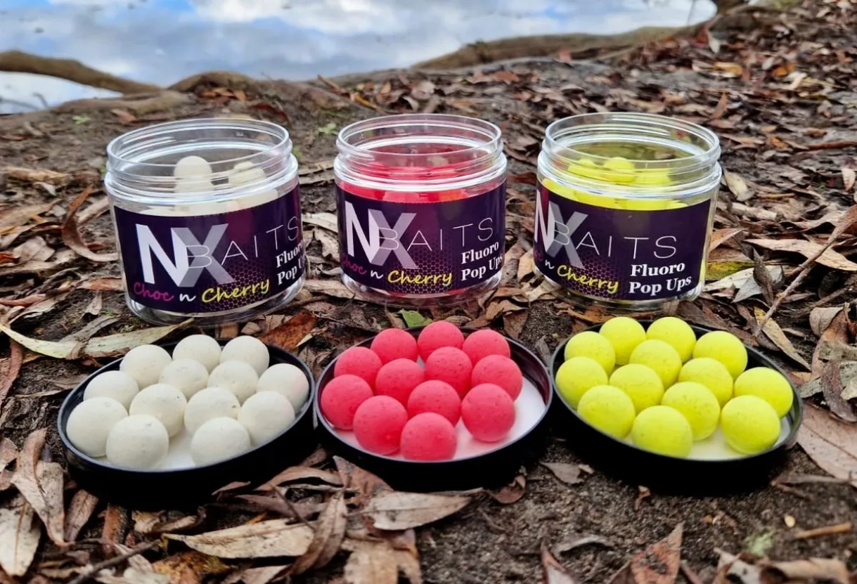 NX Baits' Ultra Buoyant Fluro Pop Ups in Day-Glo Pink, Yellow, and White colors, cherry-flavored fishing baits, ideal for UK anglers seeking top-quality bait options.